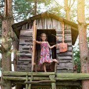 Mała chatka z drewna dla najmłodszych - oaza zabawy w ogrodzie na gałęziach i pniach